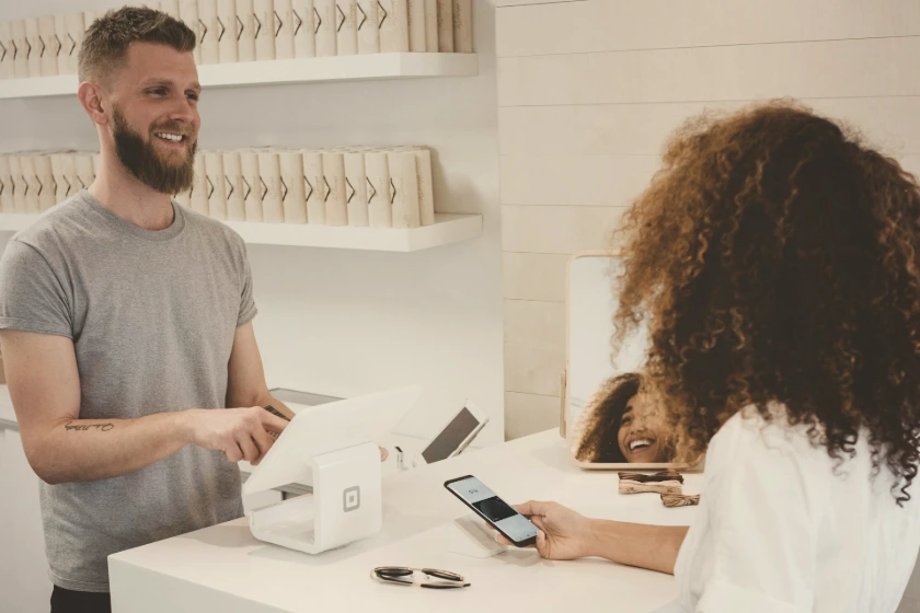 man in grey crew-neck t-shirt smiling to woman on counter